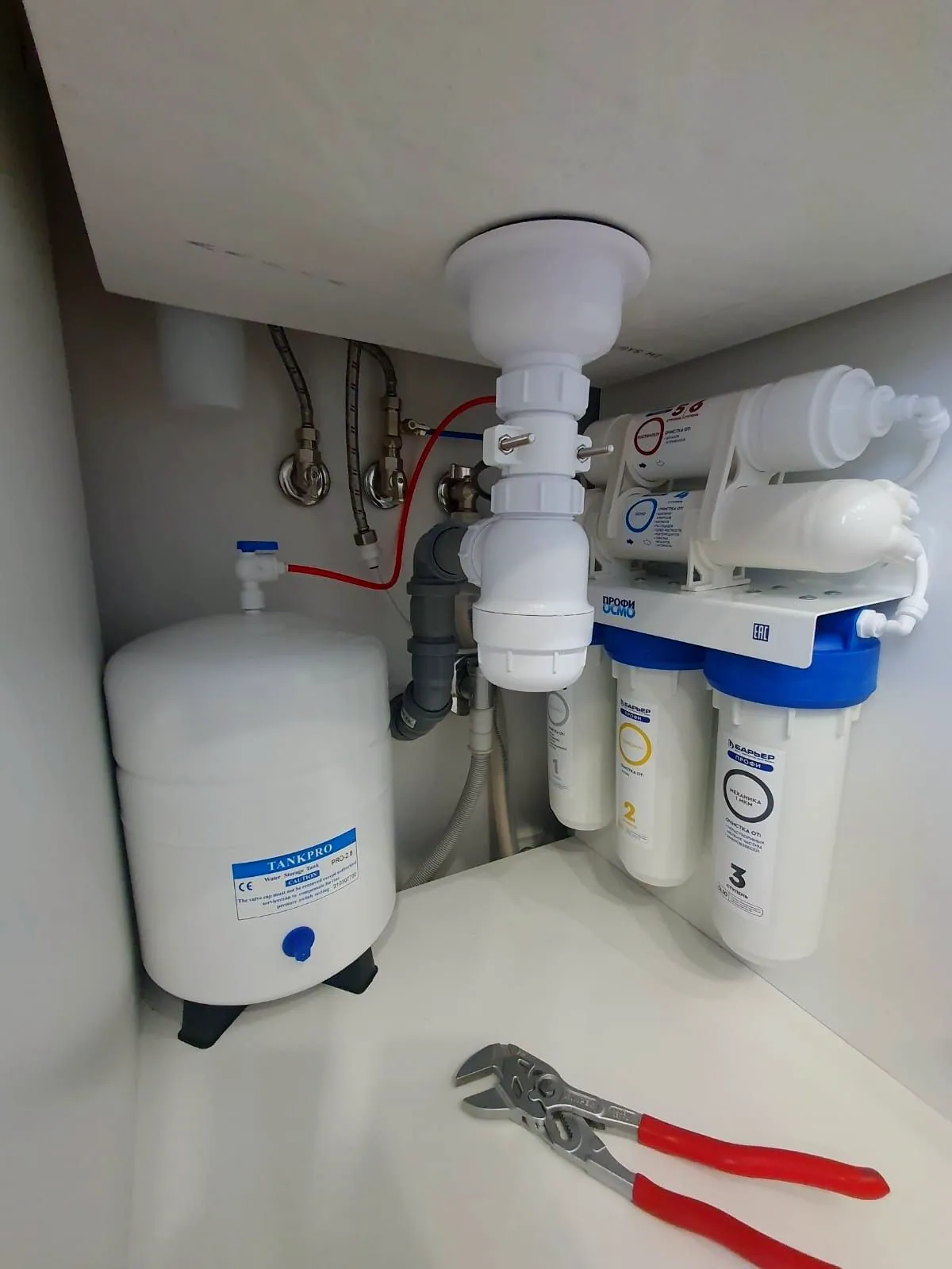 Instalación de agua ordenada bajo el fregadero de una cocina